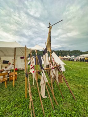 01.06.06.24.Kirchberg.Swizerland. Bir ortaçağ canlandırma etkinliği. Çimenli bir alanda çarpışan zırhlı şövalyeler dramatik bulutlu bir gökyüzü altında izleyicilerle çevrili.