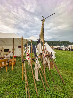 01.06.06.24.Kirchberg.Swizerland. Bir ortaçağ canlandırma etkinliği. Çimenli bir alanda çarpışan zırhlı şövalyeler dramatik bulutlu bir gökyüzü altında izleyicilerle çevrili.