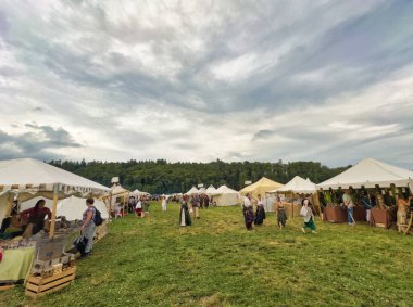 01.06.06.24.Kirchberg.Swizerland. Bir ortaçağ canlandırma etkinliği. Çimenli bir alanda çarpışan zırhlı şövalyeler dramatik bulutlu bir gökyüzü altında izleyicilerle çevrili.