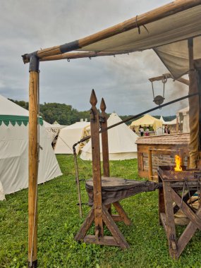 01.06.06.24.Kirchberg.Swizerland. Bir ortaçağ canlandırma etkinliği. Çimenli bir alanda çarpışan zırhlı şövalyeler dramatik bulutlu bir gökyüzü altında izleyicilerle çevrili.