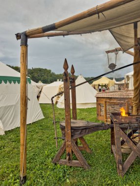01.06.06.24.Kirchberg.Swizerland. Bir ortaçağ canlandırma etkinliği. Çimenli bir alanda çarpışan zırhlı şövalyeler dramatik bulutlu bir gökyüzü altında izleyicilerle çevrili.