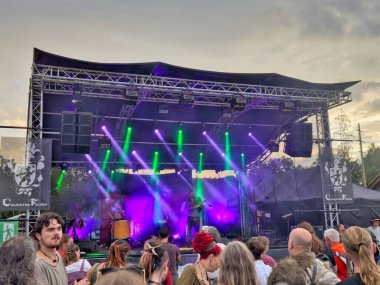 01.06.06.24.Kirchberg.Swizerland. Bir ortaçağ canlandırma etkinliği. Çimenli bir alanda çarpışan zırhlı şövalyeler dramatik bulutlu bir gökyüzü altında izleyicilerle çevrili.