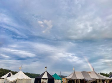 01.06.06.24.Kirchberg.Swizerland. Bir ortaçağ canlandırma etkinliği. Çimenli bir alanda çarpışan zırhlı şövalyeler dramatik bulutlu bir gökyüzü altında izleyicilerle çevrili.