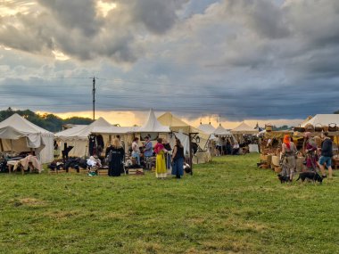 01.06.06.24.Kirchberg.Swizerland. Bir ortaçağ canlandırma etkinliği. Çimenli bir alanda çarpışan zırhlı şövalyeler dramatik bulutlu bir gökyüzü altında izleyicilerle çevrili.