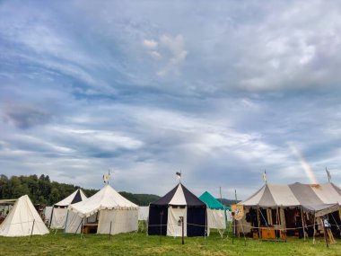01.06.06.24.Kirchberg.Swizerland. Bir ortaçağ canlandırma etkinliği. Çimenli bir alanda çarpışan zırhlı şövalyeler dramatik bulutlu bir gökyüzü altında izleyicilerle çevrili.
