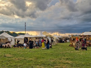 01.06.06.24.Kirchberg.Swizerland. Bir ortaçağ canlandırma etkinliği. Çimenli bir alanda çarpışan zırhlı şövalyeler dramatik bulutlu bir gökyüzü altında izleyicilerle çevrili.