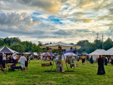 01.06.06.24.Kirchberg.Swizerland. Bir ortaçağ canlandırma etkinliği. Çimenli bir alanda çarpışan zırhlı şövalyeler dramatik bulutlu bir gökyüzü altında izleyicilerle çevrili.