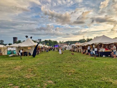 01.06.06.24.Kirchberg.Swizerland. Bir ortaçağ canlandırma etkinliği. Çimenli bir alanda çarpışan zırhlı şövalyeler dramatik bulutlu bir gökyüzü altında izleyicilerle çevrili.