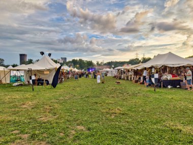 01.06.06.24.Kirchberg.Swizerland. Bir ortaçağ canlandırma etkinliği. Çimenli bir alanda çarpışan zırhlı şövalyeler dramatik bulutlu bir gökyüzü altında izleyicilerle çevrili.