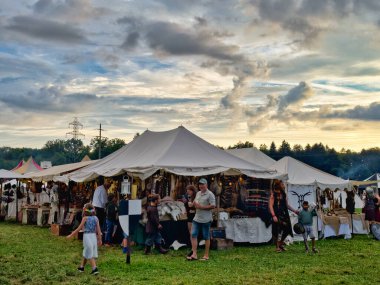01.06.06.24.Kirchberg.Swizerland. Bir ortaçağ canlandırma etkinliği. Çimenli bir alanda çarpışan zırhlı şövalyeler dramatik bulutlu bir gökyüzü altında izleyicilerle çevrili.