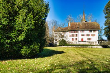 Sakin bir hendeğe yansıyan kuleleri olan bir ortaçağ kalesi.