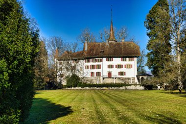 Sakin bir hendeğe yansıyan kuleleri olan bir ortaçağ kalesi.