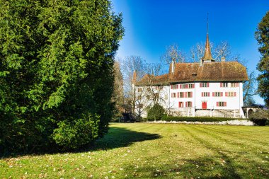 Sakin bir hendeğe yansıyan kuleleri olan bir ortaçağ kalesi.