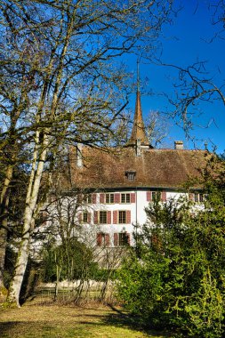 Sakin bir hendeğe yansıyan kuleleri olan bir ortaçağ kalesi.