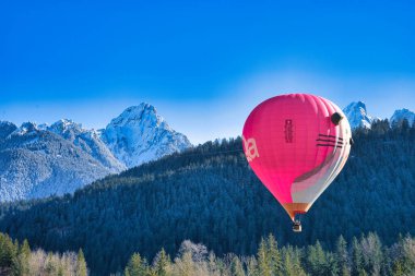 Chateau-d 'Oex, İsviçre - 1 Şubat 2025: İsviçre Alpleri' ndeki yıllık festivalde sıcak hava balonları yükseliyor