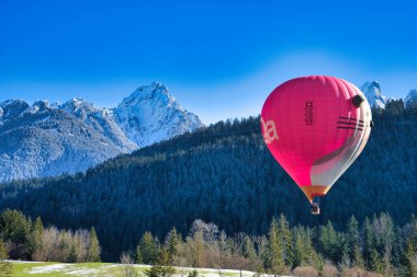 Chateau-d 'Oex, İsviçre - 1 Şubat 2025: İsviçre Alpleri' ndeki yıllık festivalde sıcak hava balonları yükseliyor