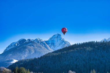 Chateau-d 'Oex, İsviçre - 1 Şubat 2025: İsviçre Alpleri' ndeki yıllık festivalde sıcak hava balonları yükseliyor