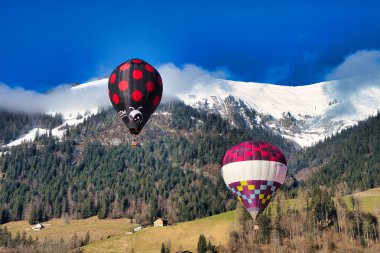 Chateau-d 'Oex, İsviçre - 1 Şubat 2025: İsviçre Alpleri' ndeki yıllık festivalde sıcak hava balonları yükseliyor