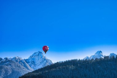 Chateau-d 'Oex, İsviçre - 1 Şubat 2025: İsviçre Alpleri' ndeki yıllık festivalde sıcak hava balonları yükseliyor