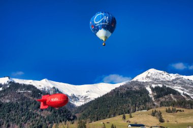 Chateau-d 'Oex, İsviçre - 1 Şubat 2025: İsviçre Alpleri' ndeki yıllık festivalde sıcak hava balonları yükseliyor
