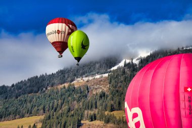 Chateau-d 'Oex, İsviçre - 1 Şubat 2025: İsviçre Alpleri' ndeki yıllık festivalde sıcak hava balonları yükseliyor