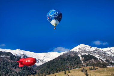 Chateau-d 'Oex, İsviçre - 1 Şubat 2025: İsviçre Alpleri' ndeki yıllık festivalde sıcak hava balonları yükseliyor
