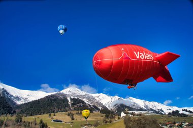 Chateau-d 'Oex, İsviçre - 1 Şubat 2025: İsviçre Alpleri' ndeki yıllık festivalde sıcak hava balonları yükseliyor