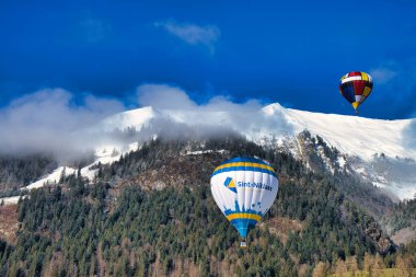Chateau-d 'Oex, İsviçre - 1 Şubat 2025: İsviçre Alpleri' ndeki yıllık festivalde sıcak hava balonları yükseliyor
