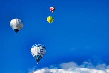 Chateau-d 'Oex, İsviçre - 1 Şubat 2025: İsviçre Alpleri' ndeki yıllık festivalde sıcak hava balonları yükseliyor