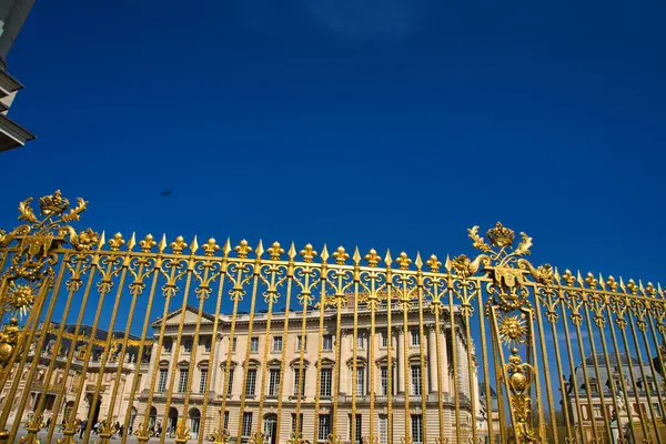 08.04.25.Paris, Fransa Versailles Sarayı 'nın altın kapısı, parlak mavi gökyüzünün altında parlıyor.