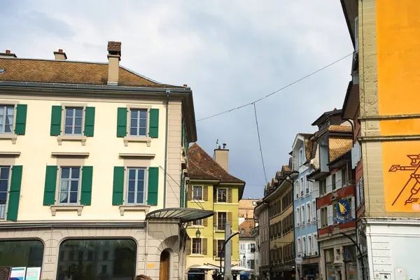 Arkasında tarihi binalar ve Alpler olan şehir manzarası