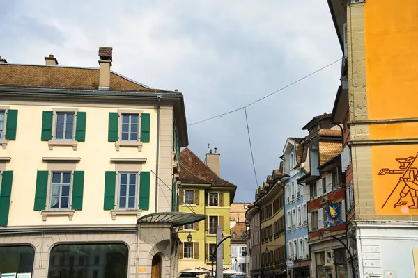 Arkasında tarihi binalar ve Alpler olan şehir manzarası