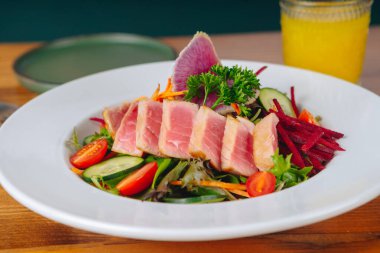 Bir tabak et ve sebzeyle birlikte bir tabak yemek.