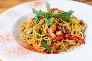 Sebzeli ve etli bir tabak erişte. Tabak beyaz tabakta servis edilir.