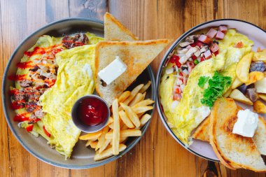 İki tabak yemek, biri sahanda yumurta, diğeri sahanda yumurta ve tost.