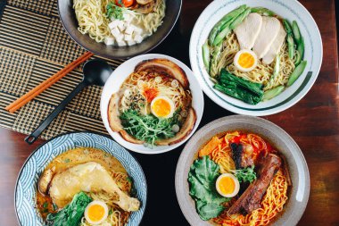 Masada çeşitli Asya erişte yemekleri sergilenir. Yemekler arasında et ve sebzeli bir kase erişte, tavuklu bir kase erişte ve sebzeli bir kase erişte yer alıyor.