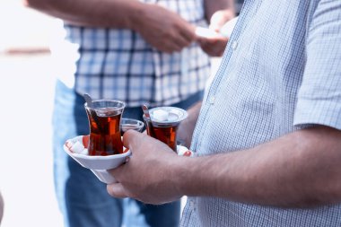 Satıcı üç Türk çayı servis ediyor. Stok fotoğrafı.