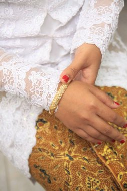 Altın alyans takan bir kadının parmağı.