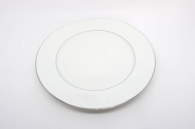 Beyaz zemin üzerinde camdan yapılmış düz, yuvarlak bir levha.