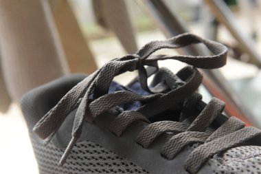 Gri ayakkabılara bağlı eski ayakkabı bağcıkları.