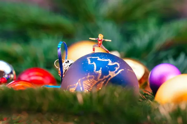Yoga pozisyonunda duran minyatür bir figür Noel ağacı süslemesinin üstünde duruyor.