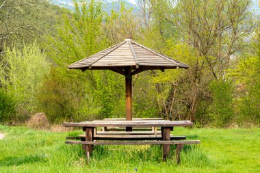 Old wooden gazebo standing next to the road in the nature