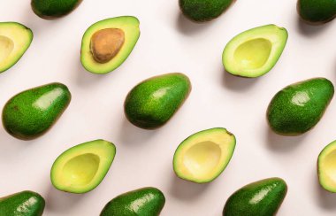 Pembe bir arka plan üzerinde avokado desen. Üstten Görünüm. Afiş. Pop sanat tasarım, yaratıcı yaz gıda kavramı. Yeşil avocadoes, en az düz stil yatıyordu..