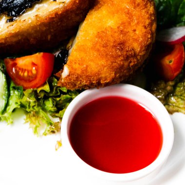 Kayısı dolu keçi peyniri ve enginar, roka ve vişneli domatesle servis edilen ceviz.