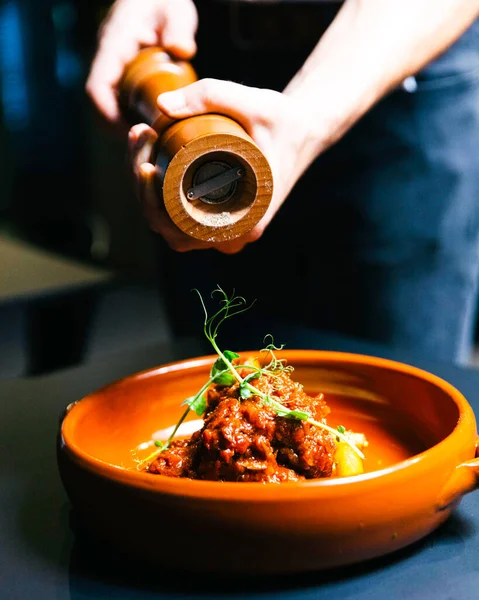 stock image Man Pouring Pepper On Beef Cheeks In A bowl