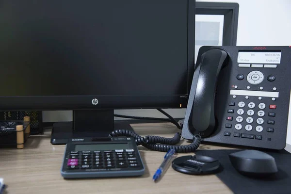 Ofis masasında telefon faresi ve klavye ile siyah renkli şeyler.