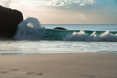 Fascinating waves and boulders on the beach Anse Lazio of the Seychelles.