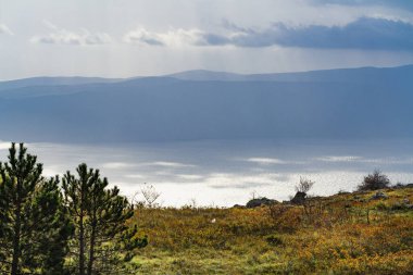 Krk adasının üzerindeki ışığa karşı Adriyatik Denizi üzerindeki atmosfer manzarası.