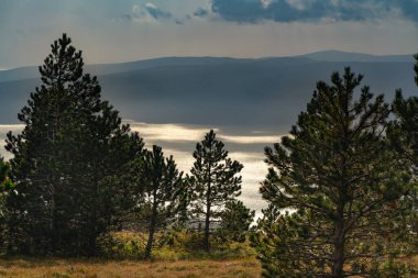 Krk adasının üzerindeki ışığa karşı Adriyatik Denizi üzerindeki atmosfer manzarası.