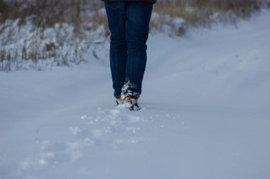 Walking man in winter steps and footprints of a man in the winter forest, winter shoes